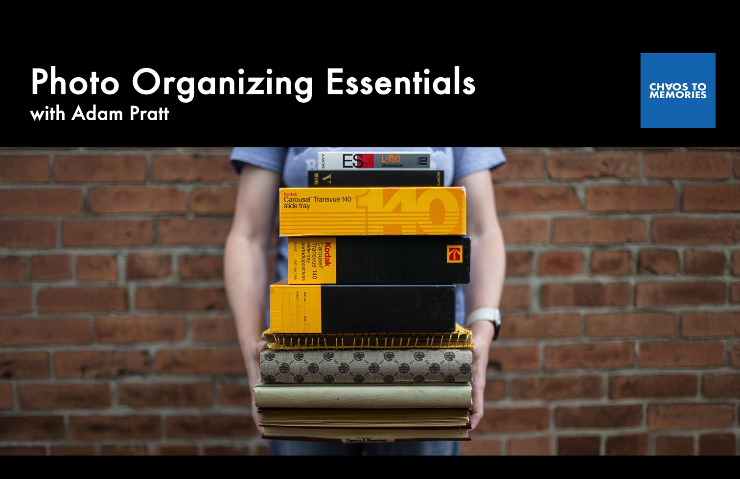 A woman holding a stack of photo albums, slide carousels, and video tapes in her arms - Photo Organizing Essentials Course